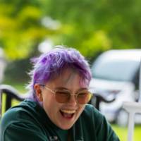 Student smiles while working a booth at Student Small Business Market.